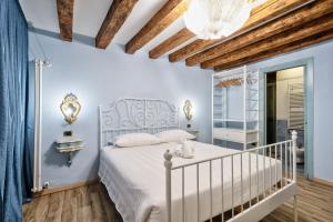 - une chambre avec un lit blanc et un lustre dans l'établissement Piccolo Vecellio, à Venise