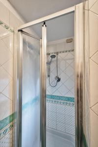 La salle de bains est pourvue d'une douche avec une porte en verre. dans l'établissement Piccolo Vecellio, à Venise
