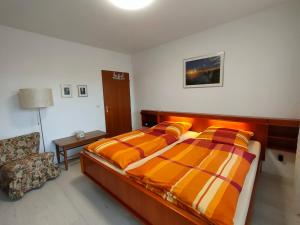 Un dormitorio con 2 camas y una silla. en Ferienwohnung Gutermuth Obereisenheim, en Fahr