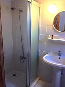 a bathroom with a shower and a sink at Bare Hill Holiday Apartments in Kérynia
