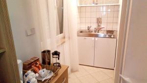 a small white kitchen with a sink and a counter at Old Town Charmer in Poreč