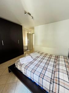 um quarto com uma cama com um cobertor xadrez em APPARTAMENTO LA CAFFETTERIA em Rovereto