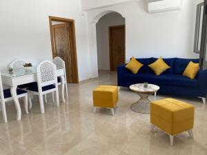 sala de estar con sofá azul, mesa y sillas en La casa blanca en Houmt El Souk