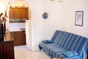 a living room with a blue couch in a kitchen at Apartments with a parking space Seget Vranjica, Trogir - 8623 in Seget Vranjica