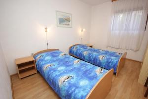 two beds in a small room with at Apartments with a parking space Seget Vranjica, Trogir - 8623 in Seget Vranjica