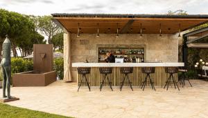un bar al aire libre con taburetes en un patio en Castelfalfi, en Castelfalfi