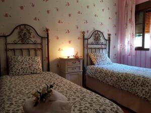 1 dormitorio con 2 camas y mesa con lámpara en Vivienda Rural Casa Sofía en Ubrique