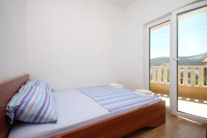 1 dormitorio con cama y ventana grande en Apartments by the sea Poljica, Trogir - 8682 en Marina