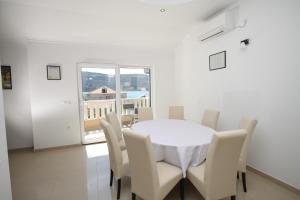 un comedor blanco con una mesa y sillas blancas en Apartments by the sea Poljica, Trogir - 8682 en Marina