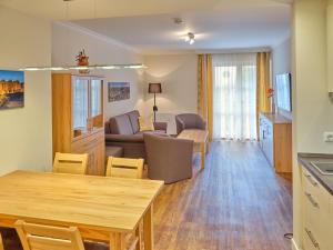 ein Wohnzimmer mit einem Tisch und einem Sofa in der Unterkunft Appartement-Haus Blumenhof in Bad Griesbach