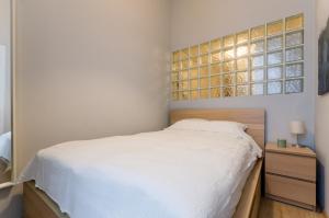 1 dormitorio con cama blanca y cabecero de madera en I30 Studio Apartment In Central Location., en Budapest