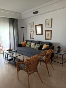 sala de estar con sofá azul y 2 mesas en Espectacular apartamento primera linea de playa - Golf, en Estepona