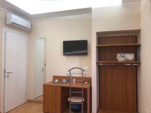 a room with a desk and a tv on a wall at Le Affacciate Bruzie Home 2 Guest House in Cosenza