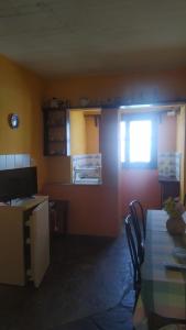 Pokój ze stołem, krzesłami i oknem w obiekcie Traditional apartment in Mylopotamos Beach w mieście Tsagarada