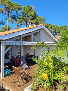 a house with a wooden deck with chairs on it at Location Meublée La Teste in La Teste-de-Buch