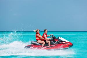 two people riding a jet ski in the water at Heritance Aarah-Premium All Inclusive in Raa Atoll