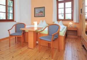 a room with a table and chairs and a bed at Pension Altes Posthaus in Dangast