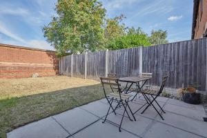a table and chairs on a patio with a fence at Modern 2 Bed House Near Queens Medical Centre in Nottingham