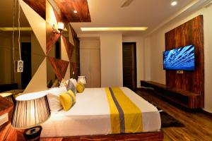 a bedroom with a bed and a tv in a room at Hotel The Yellow in Chandīgarh