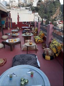 a patio with tables and couches on a balcony at Riad lala zakia in Moulay Idriss