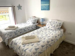 een slaapkamer met 2 bedden en handdoeken bij Royal Oak Cottage in Amlwch