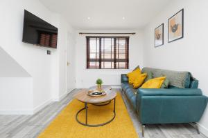 a living room with a blue couch and a table at Modern 2 Bed House Near Queens Medical Centre in Nottingham