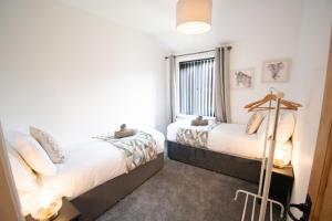 a bedroom with two beds and a window at Ideal Lodgings in Bury in Bury