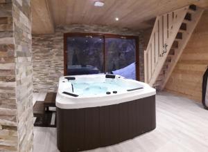 a jacuzzi tub in a room with a staircase at Chalet cocody jacuzz in Jausiers