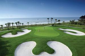 a view of a golf course with the ocean in the background at Omni Hilton Head Oceanfront Resort in Hilton Head Island