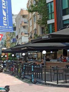 a restaurant with tables and umbrellas on a city street at NEXT TO CAFES, BEACH AND ALL AMENITIES in Antalya