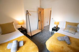 a bedroom with two beds and two lamps and a mirror at Ideal Lodgings in Bury in Bury