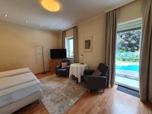 1 dormitorio con 1 cama, mesa y sillas en Hotel Hotwagner, en Maria Enzersdorf