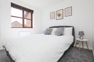 a white bedroom with a white bed and a window at Modern 2 Bed House Near Queens Medical Centre in Nottingham