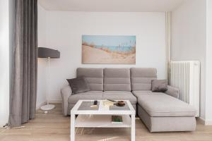 a living room with a couch and a table at Gdańska Two-bedroom Apartment Brzeźno Beach by Renters in Gdańsk