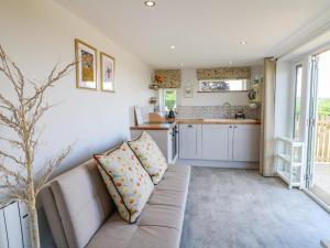 a living room with a couch and a kitchen at Cuckoo Nest in Chesterfield