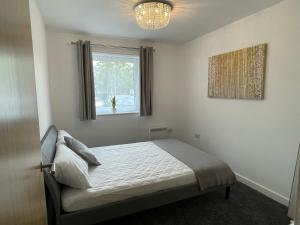 a bedroom with a bed and a window at Moda Wigan - Stylish 2 Bed Apartment Central Wigan in Wigan