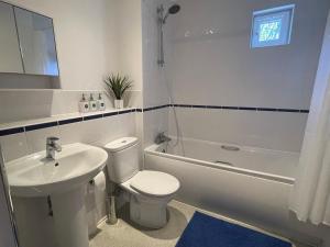 a bathroom with a toilet and a sink and a tub at Moda Wigan - Stylish 2 Bed Apartment Central Wigan in Wigan