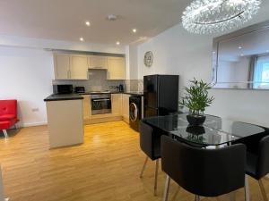 a kitchen and dining room with a table and chairs at Moda Wigan - Stylish 2 Bed Apartment Central Wigan in Wigan