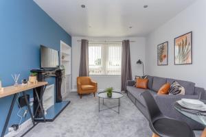 un soggiorno con divano e tavolo di Lovely 2-bed upper villa in Kirkliston Edi Airport a Edimburgo