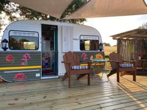 an rv with a table and chairs on a deck at Hluhluwe Bush Camp Glamping Village in Hluhluwe