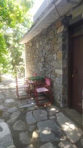 stół i krzesła siedzące poza kamiennym budynkiem w obiekcie Traditional apartment in Mylopotamos Beach w mieście Tsagarada
