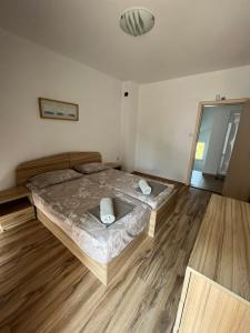 ソゾポルにあるOver the Bay Villas - Sozopolのウッドフロアのベッドルーム1室(ベッド1台付)