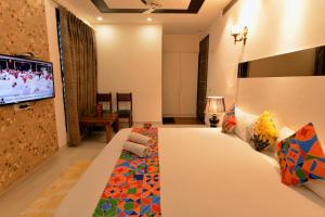 a hotel room with a bed and a flat screen tv at Hotel The Yellow in Chandīgarh