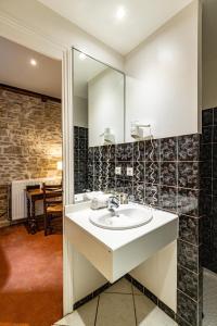 a bathroom with a sink and a mirror at Hôtel des Tonneliers in Beaune