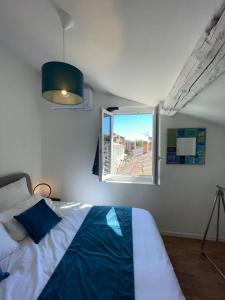 1 dormitorio con cama y ventana en La roue des teinturiers, en Aviñón