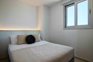 Cama en habitación con ventana en Phaedrus Living - Seaside Executive Flat Harbour 203, en Paphos
