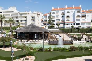 Una vista de un complejo turístico con una fuente y un edificio. en Ondamar Hotel Apartamentos, en Albufeira