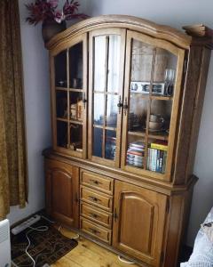 a wooden cabinet with glass doors in a room at Konak Mileva in Sjenica