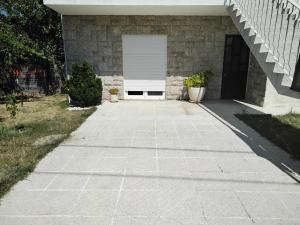 a driveway leading to a garage with a white garage door at Casa do Campo in Seia