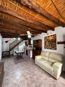 a living room with a couch and a kitchen at Luby Cortijo El Horno in Lubrín